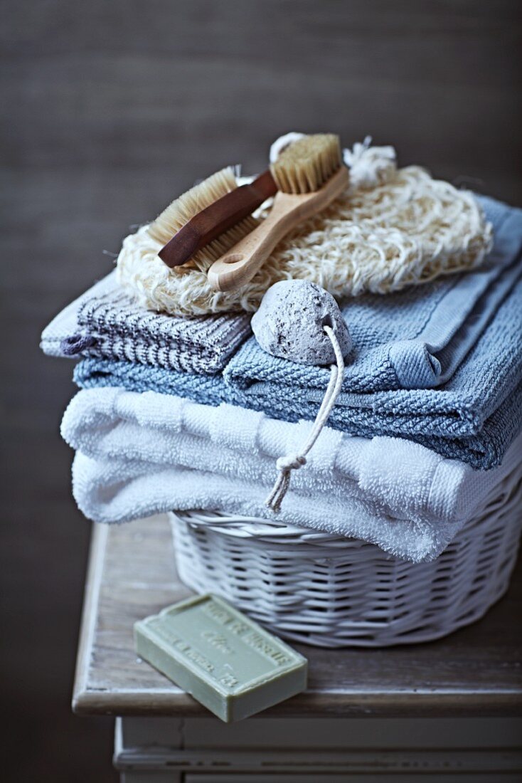 Still-life arrangement of toiletries, bath towels and organic olive oil soap