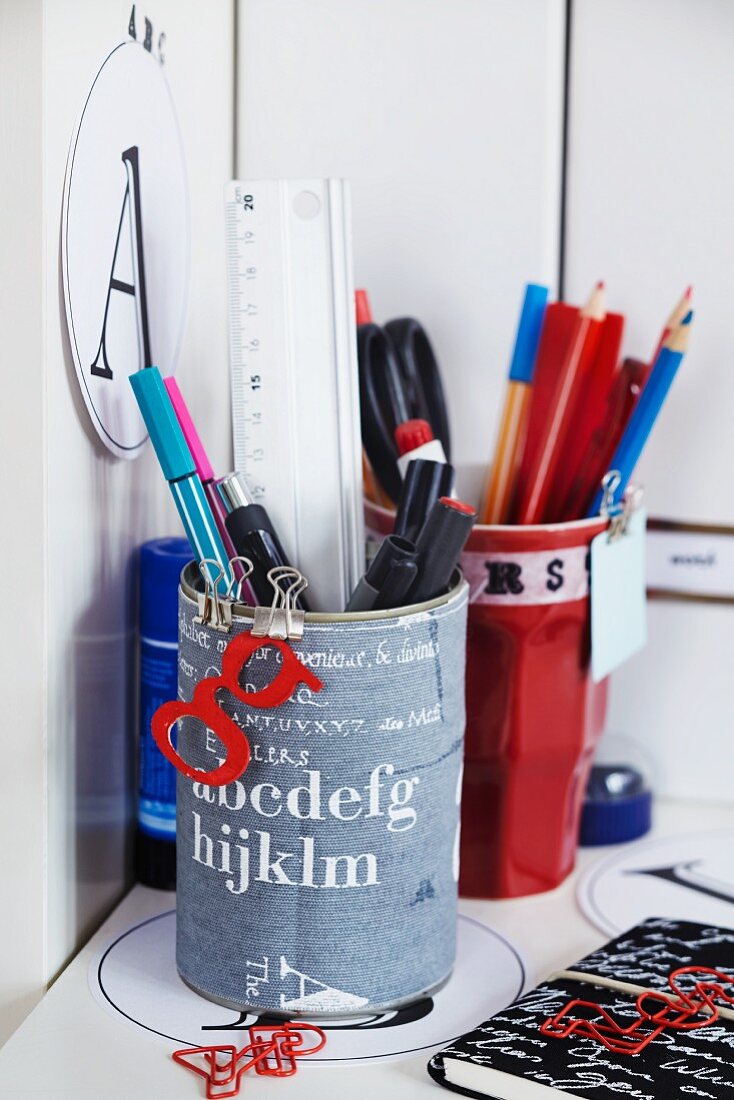 Stiftebecher mit aufgeklebtem Buchstabendesign auf Schreibtisch