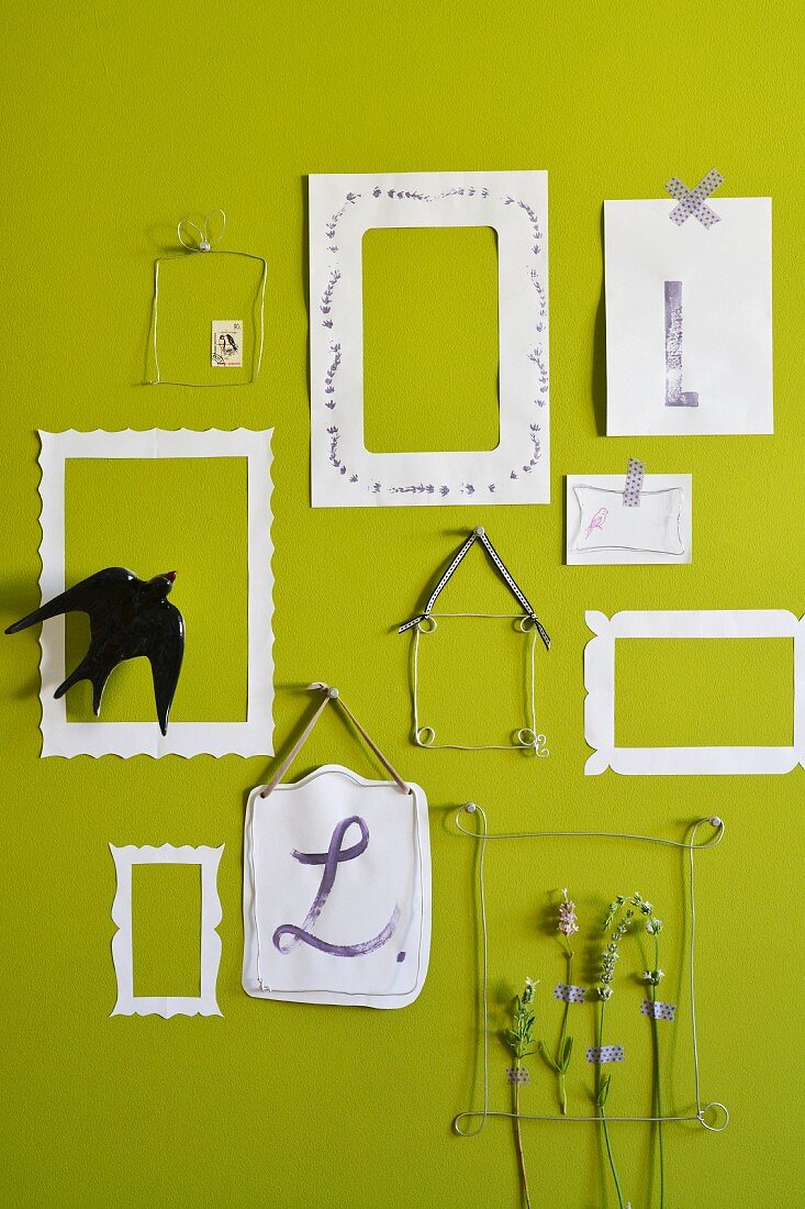 Lavendelstiele in Bilderrahmen aus Draht und Papier an grüner Wand