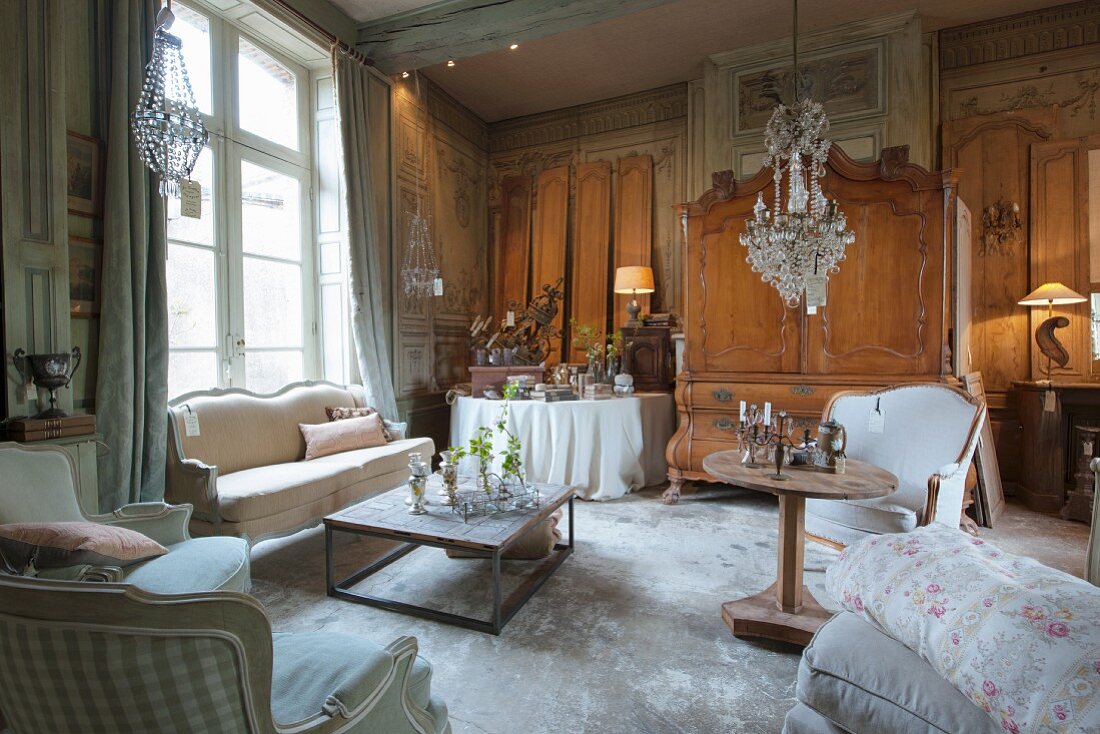 Verkaufsausstellung antiker Möbel und Kronleuchter mit Preisschildern im Salon eines alten, französischen Landhauses