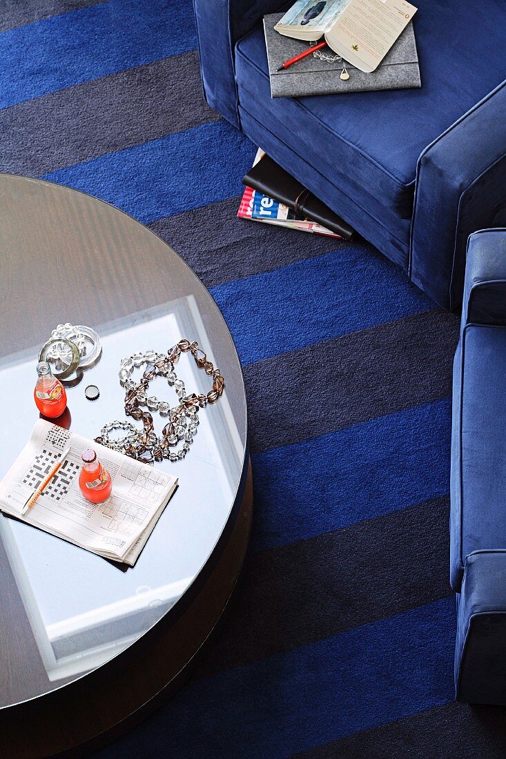 Coffee table and blue armchair on striped carpet