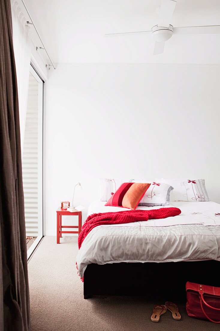 Bedroom - white bed linen and red scatter cushion on double bed in minimalist ambiance