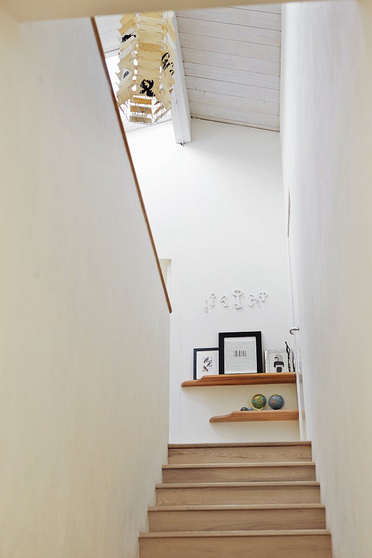 Schmaler Treppenaufgang, Blick in Dachstuhl auf Hängeleuchte an weiss gestrichener Holzdecke