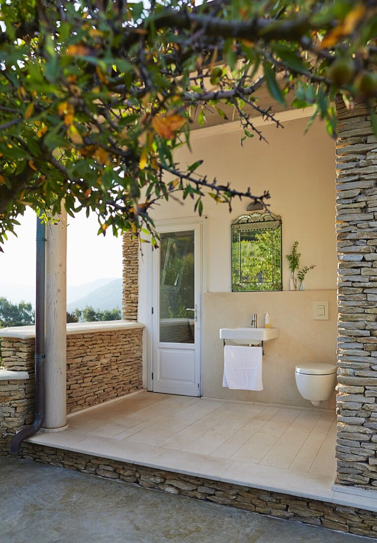 Mediterranes Natursteinhaus mit Waschbecken und Toilette auf der Terrasse