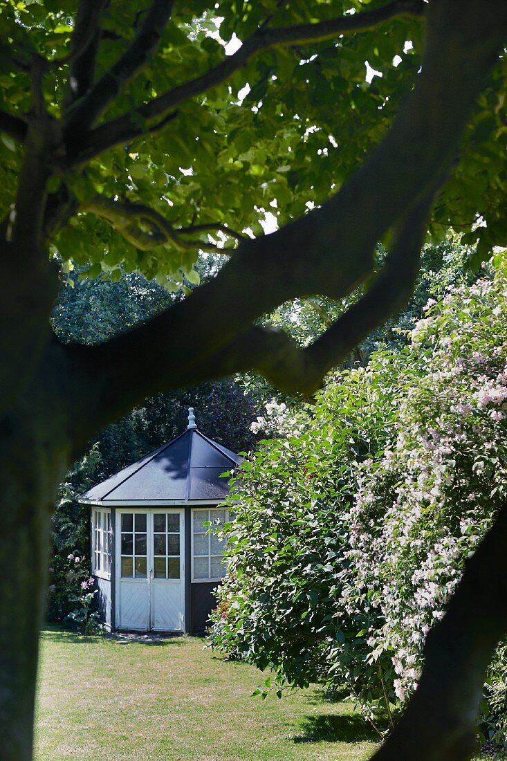 Runder Pavillon mit Sprossenfenstern in sommerlichem Garten