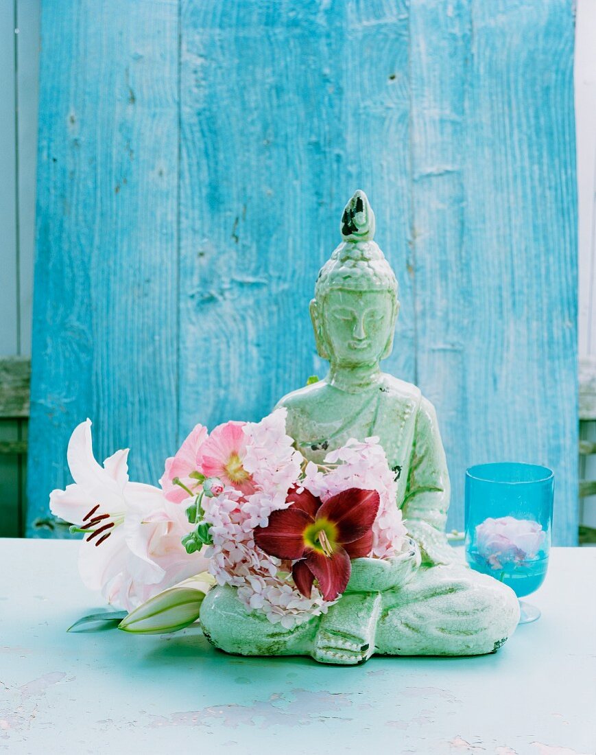Buddha ornament with hollyhock and lilies