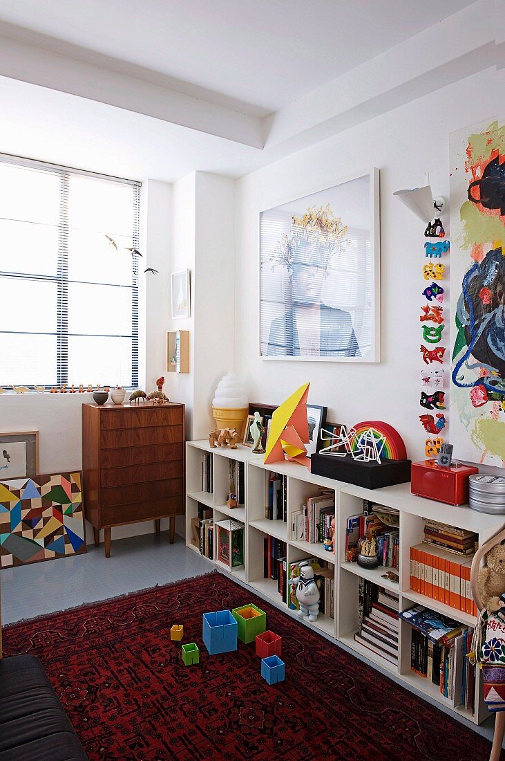 Modern art above open-fronted shelves in child's bedroom