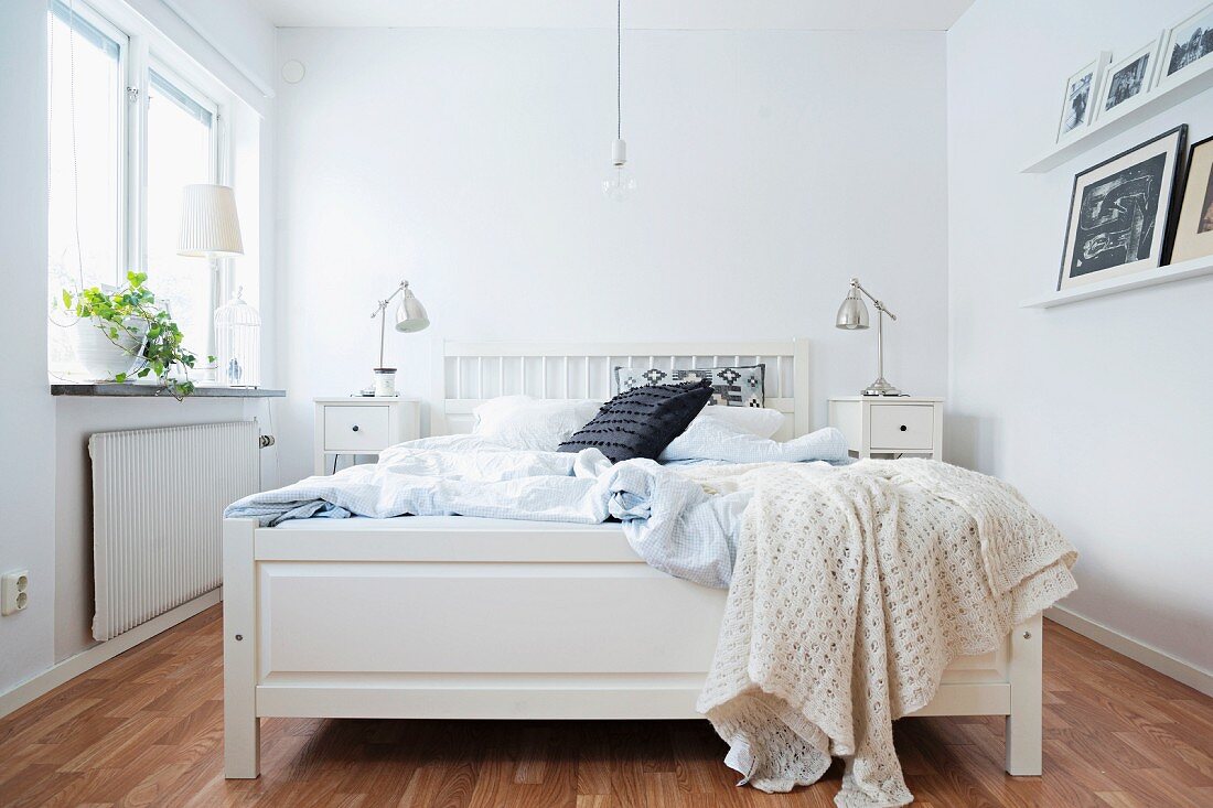 White wooden bed in rustic bedroom