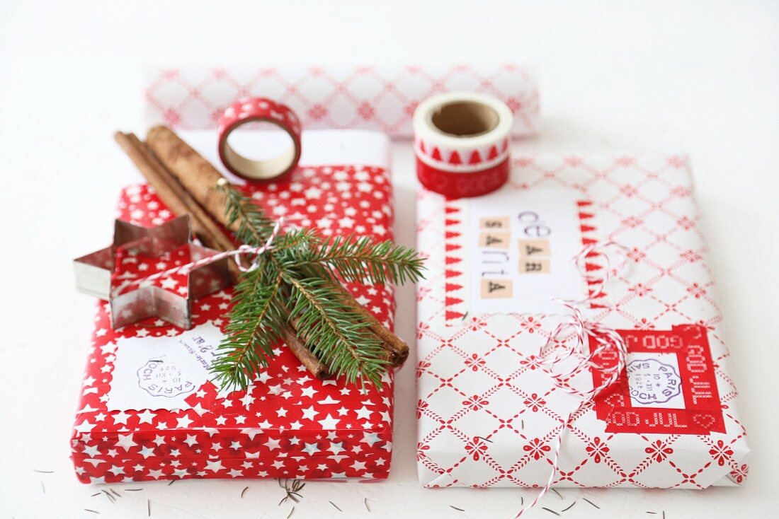 Verpackte Weihnachtsgeschenke (Washi Tape, Stempel, Papier, Zimtstangen, Kordel, Keksausstecher)