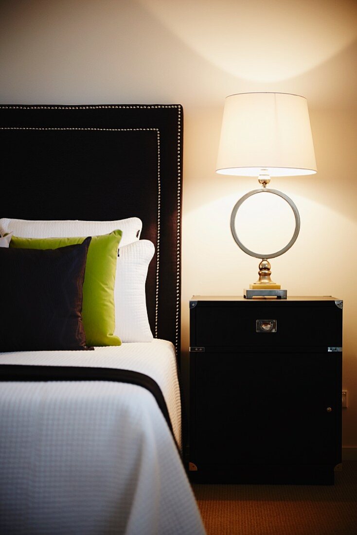 Stilvolles Schlafzimmer mit Designerlampe am Nachtkästchen