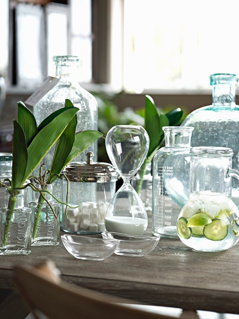 Arrangement verschiedener Glasgefäße auf einem Holztisch im eleganten Landhausstil