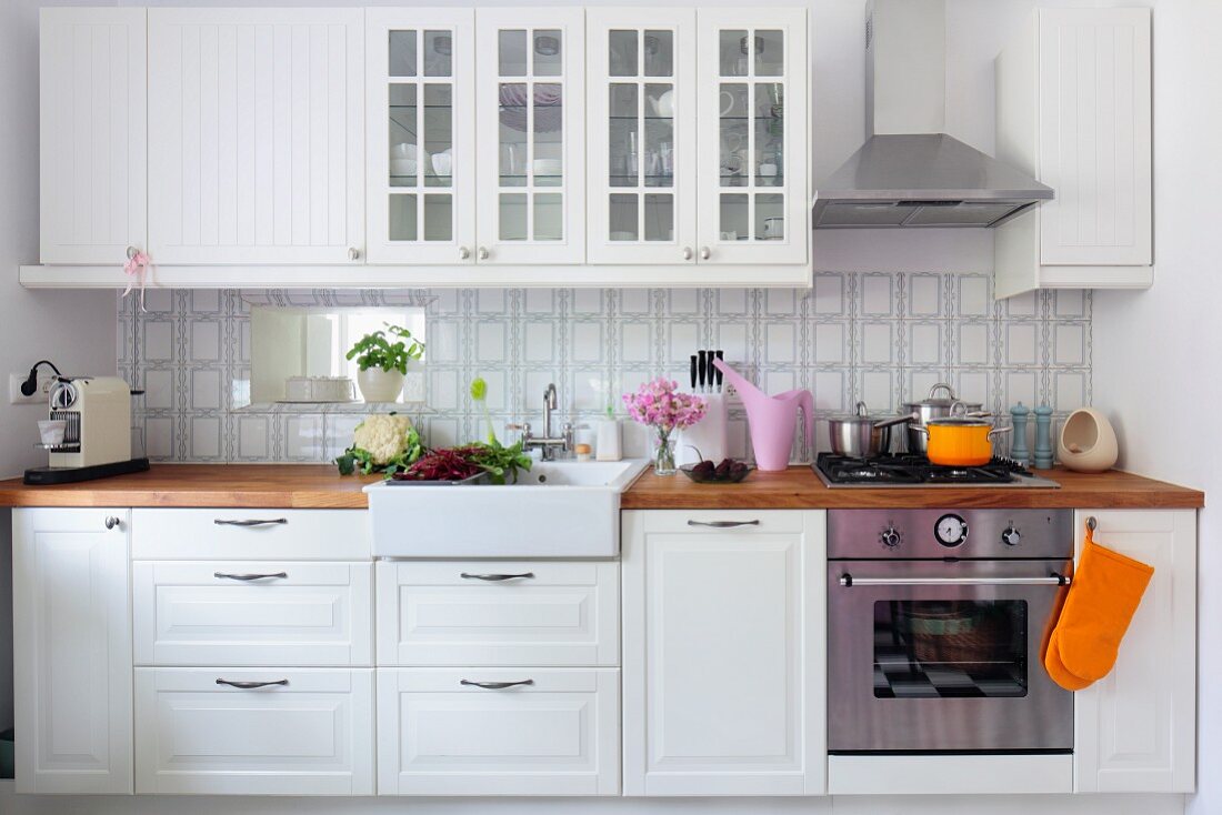 weiße Landhausküche, Hängeschränke mit Sprossentüren über Küchenzeile mit Holzarbeitsplatte