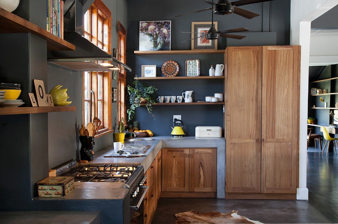 Masonry kitchen counters with solid wooden doors in open-plan kitchen with black-painted wall