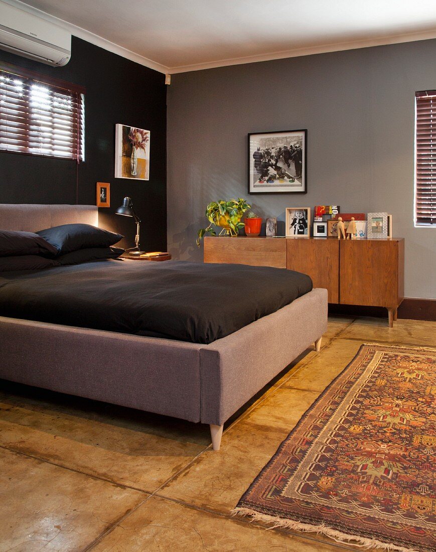 Doppelbett mit gepolstertem Rahmen in Grau und schwarze Bettwäsche in dunkel getöntem Elternschlafzimmer