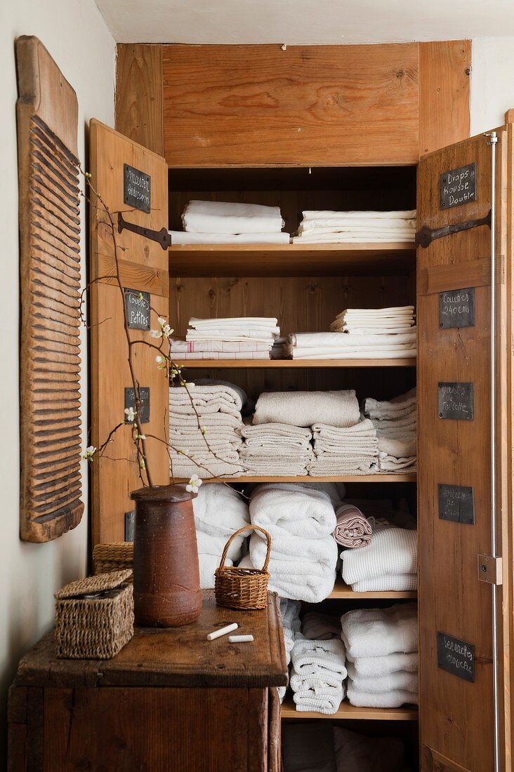 Offener, rustikaler Wäscheschrank aus Holz in Wandnische eingebaut