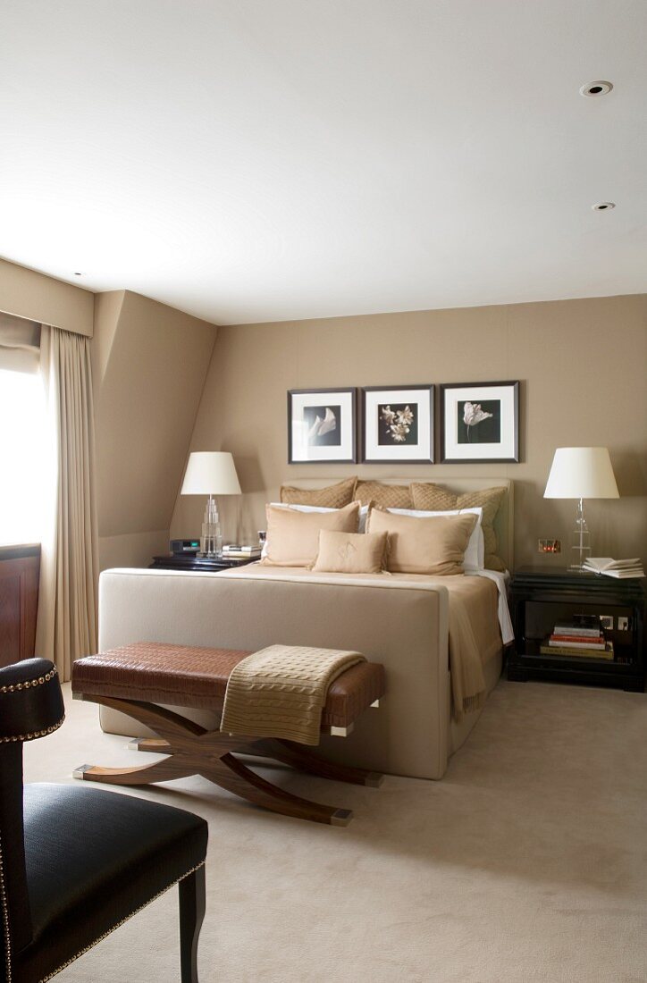 Elegantes Schlafzimmer mit beigefarbenen Polsterbett, Ton in Ton mit Wandfarbe und Teppichboden