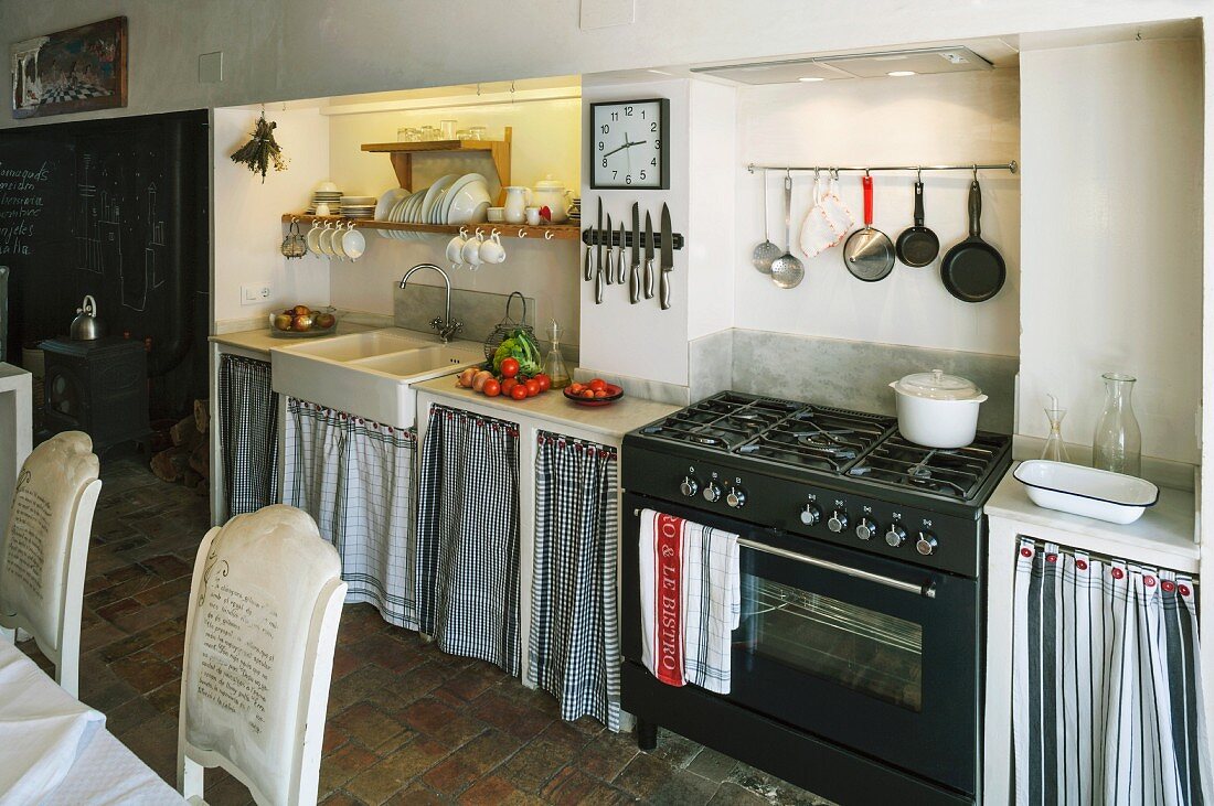 Schlichte Küchenzeile mit Vorhang an Unterschränken neben Gasherd