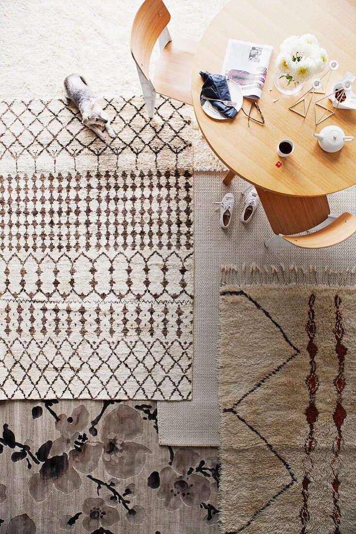 Teppiche in neutralen Tönen in einem Zimmer mit Holztisch und Stühlen