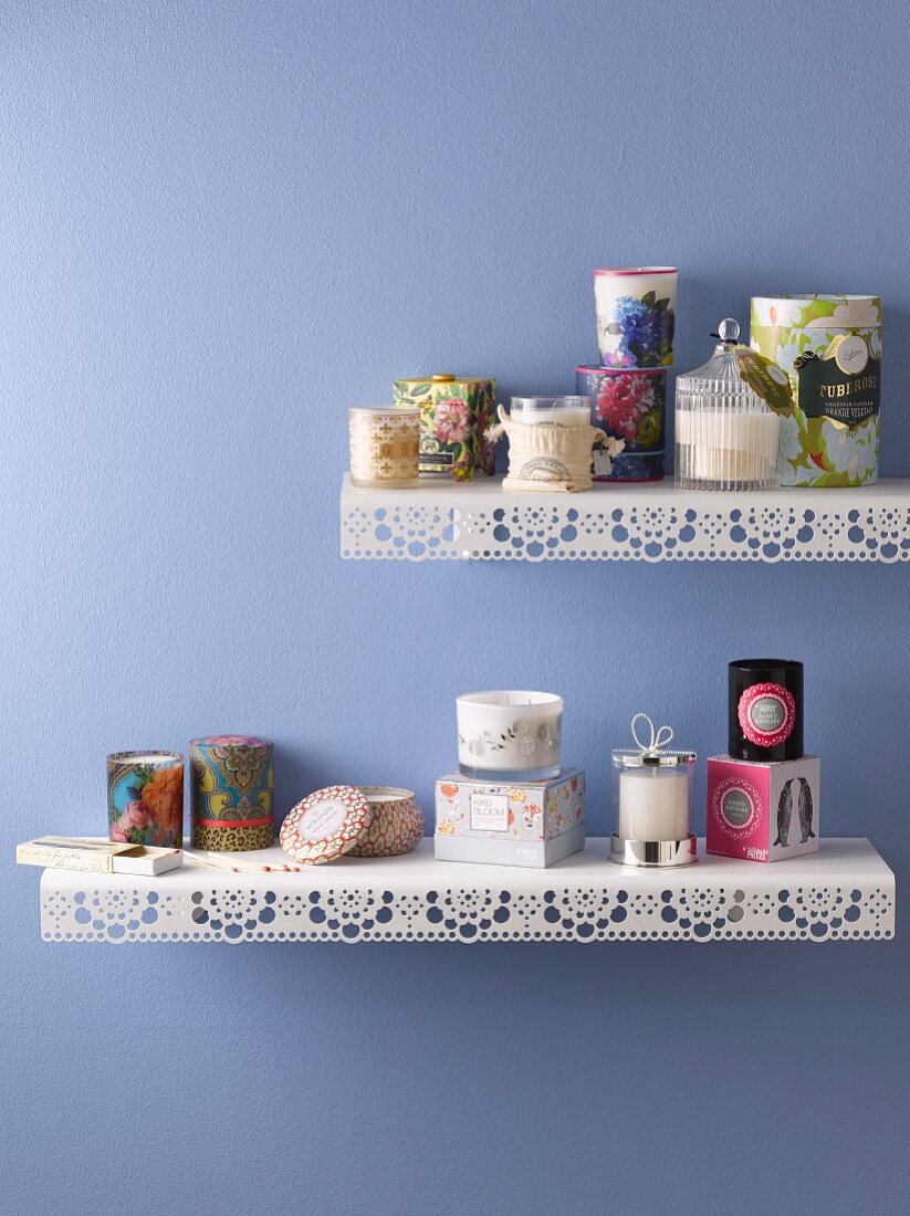 Various scented candles on metal shelves with punched trim