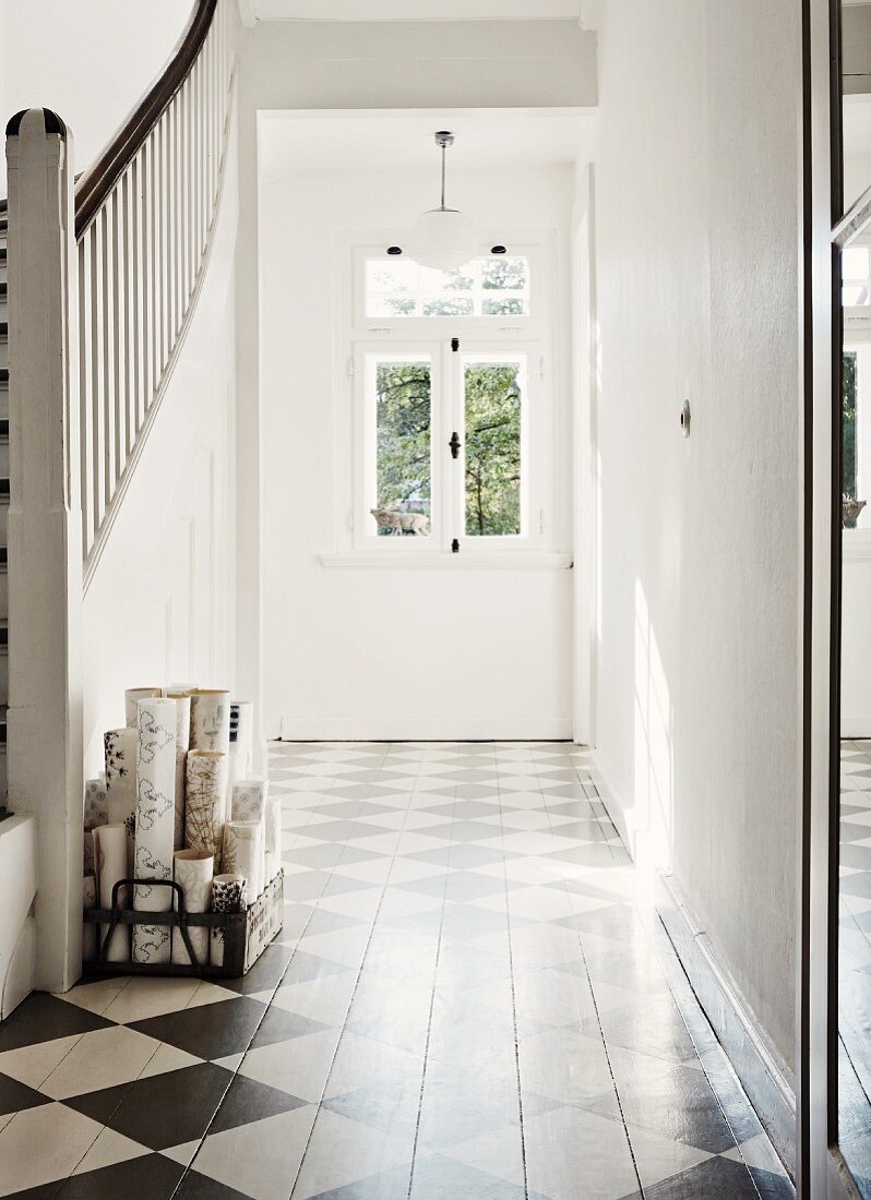 Traditional entrance with painted, chequered wooden floor and staircase to one side