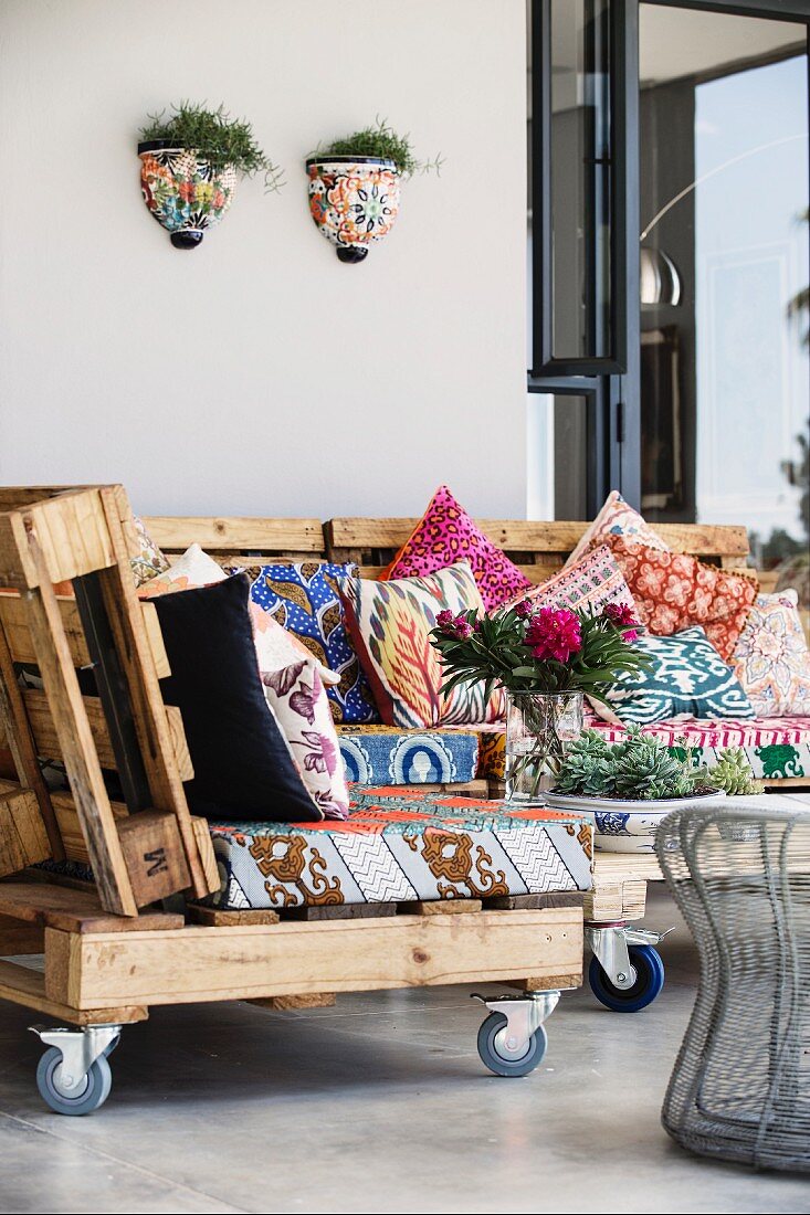 Selbstgefertigte Sofa-Elemente mit gemusterten Sitzpolstern auf Holzpaletten