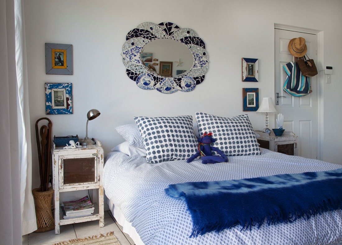 Doppelbett mit Bettwäsche in weiss-blauem Punktemuster, daneben Shabby Nachtkästchen in Schlafzimmer