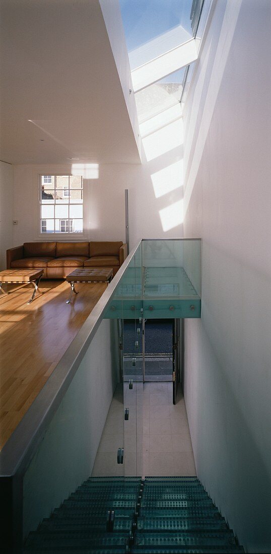Open staircase - above, a slanted skylight strip and minimalist living room