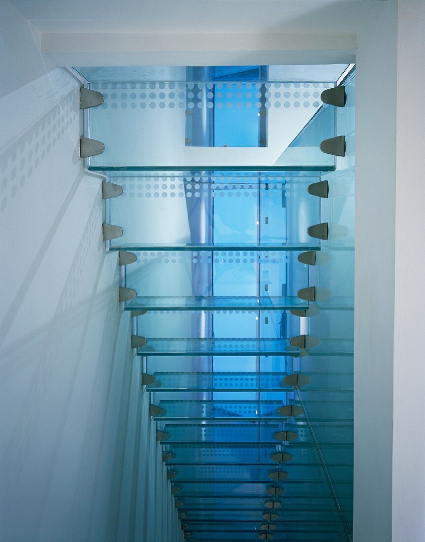 Underside view of narrow glass stairs with 'dot-like' stainless steel brackets