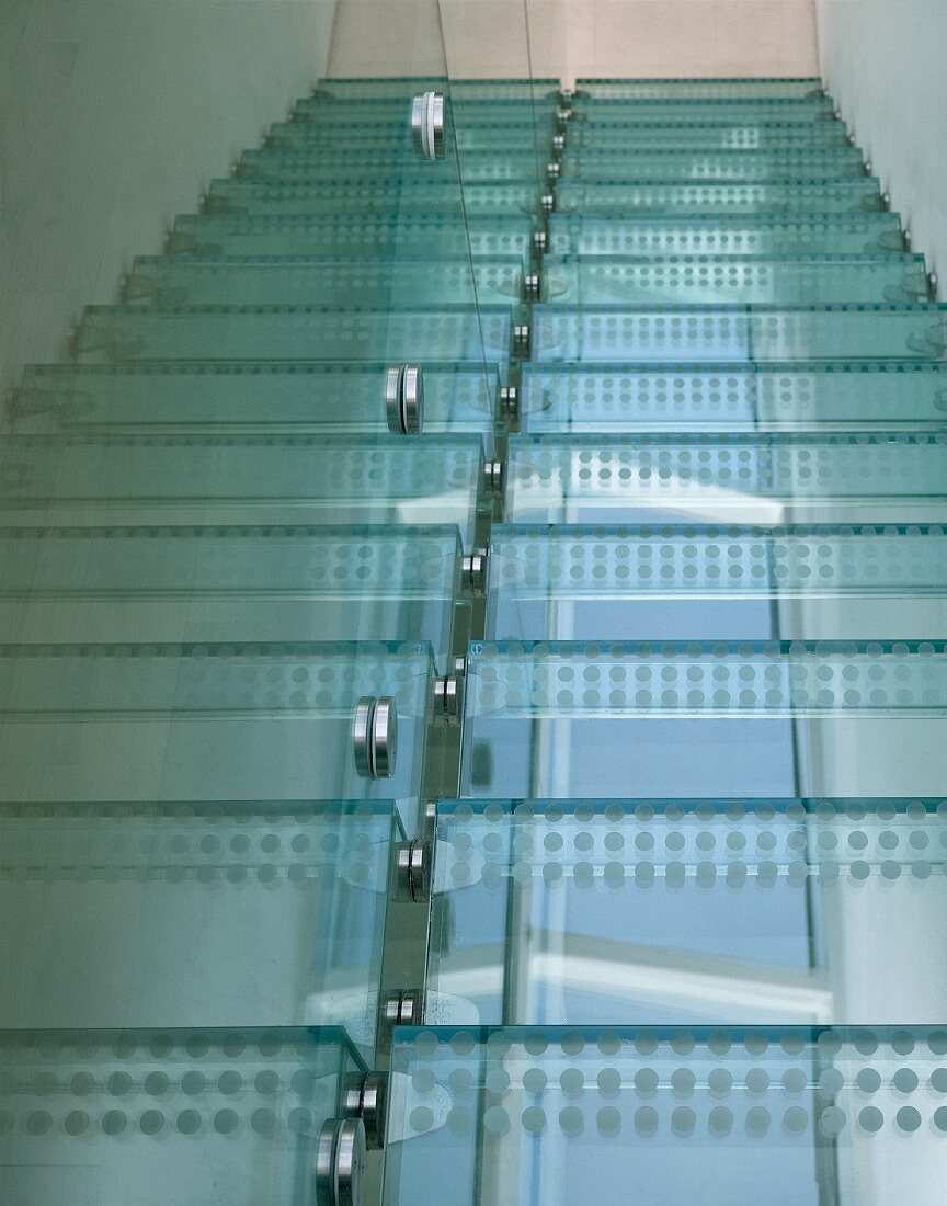Ausschnitt einer modernen Treppe mit Glasstufen und aufgeklebter Punktfolie und Edelstahlbefestigung