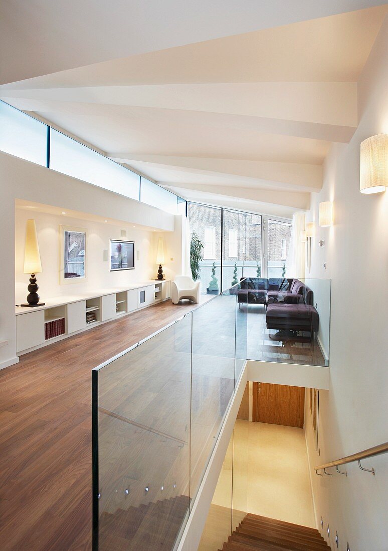 Offener Wohnraum im Designerlook mit gefalteter Deckenkonstruktion und Blick auf Treppenabgang