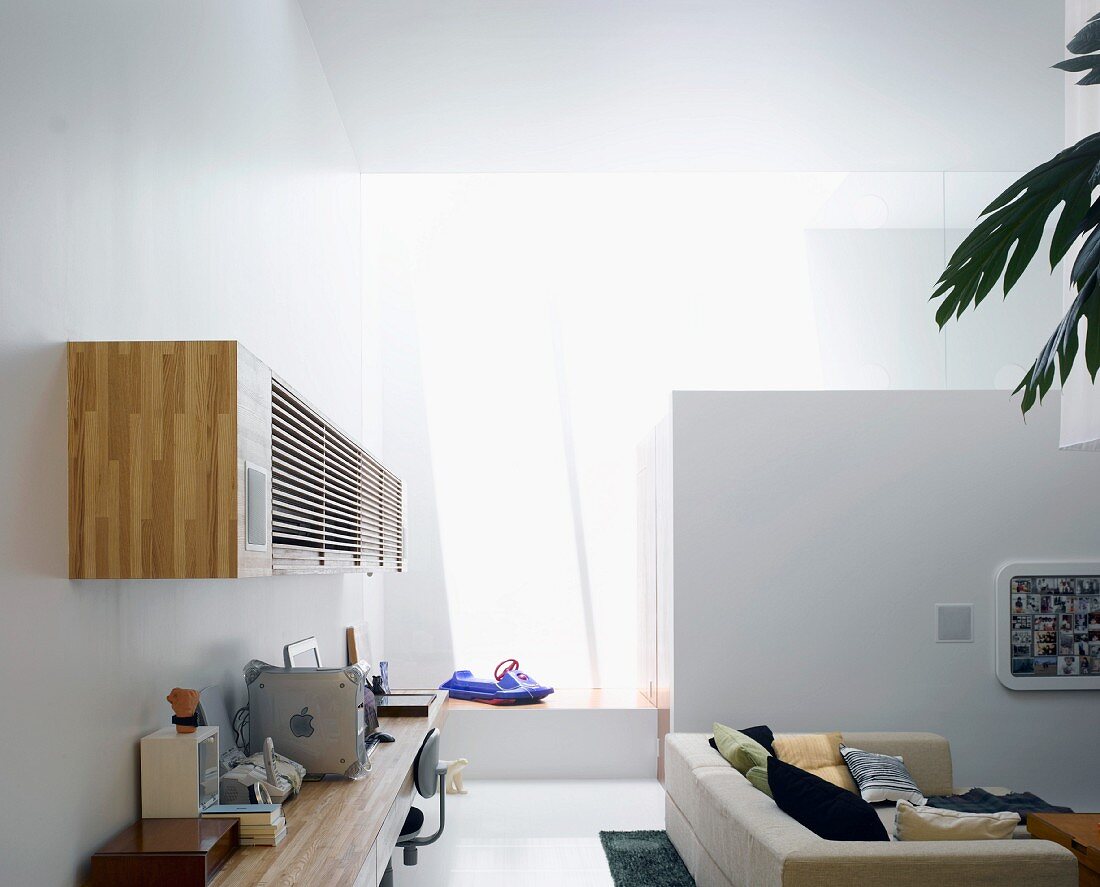 Arbeitstisch und Hängeschrank aus Holz an Wand im modernen Wohnraum