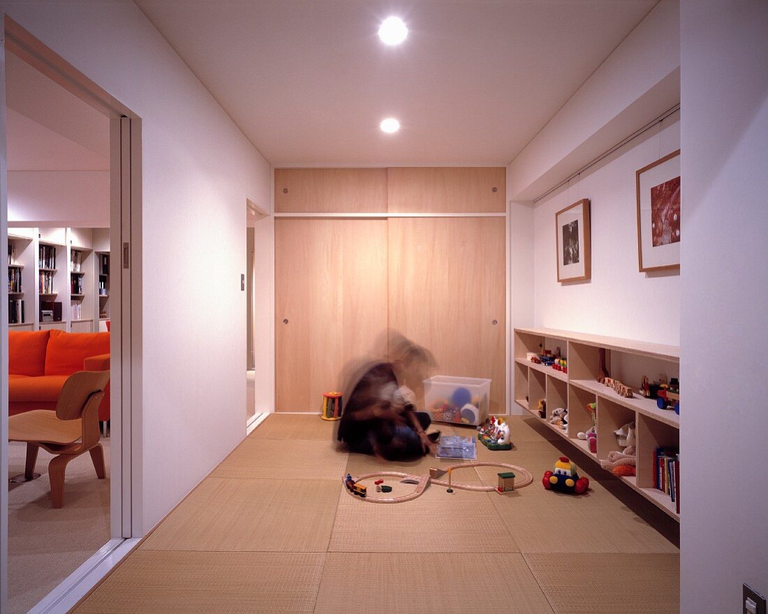 Mann und Kind im Spielzimmer auf Tatamimatten