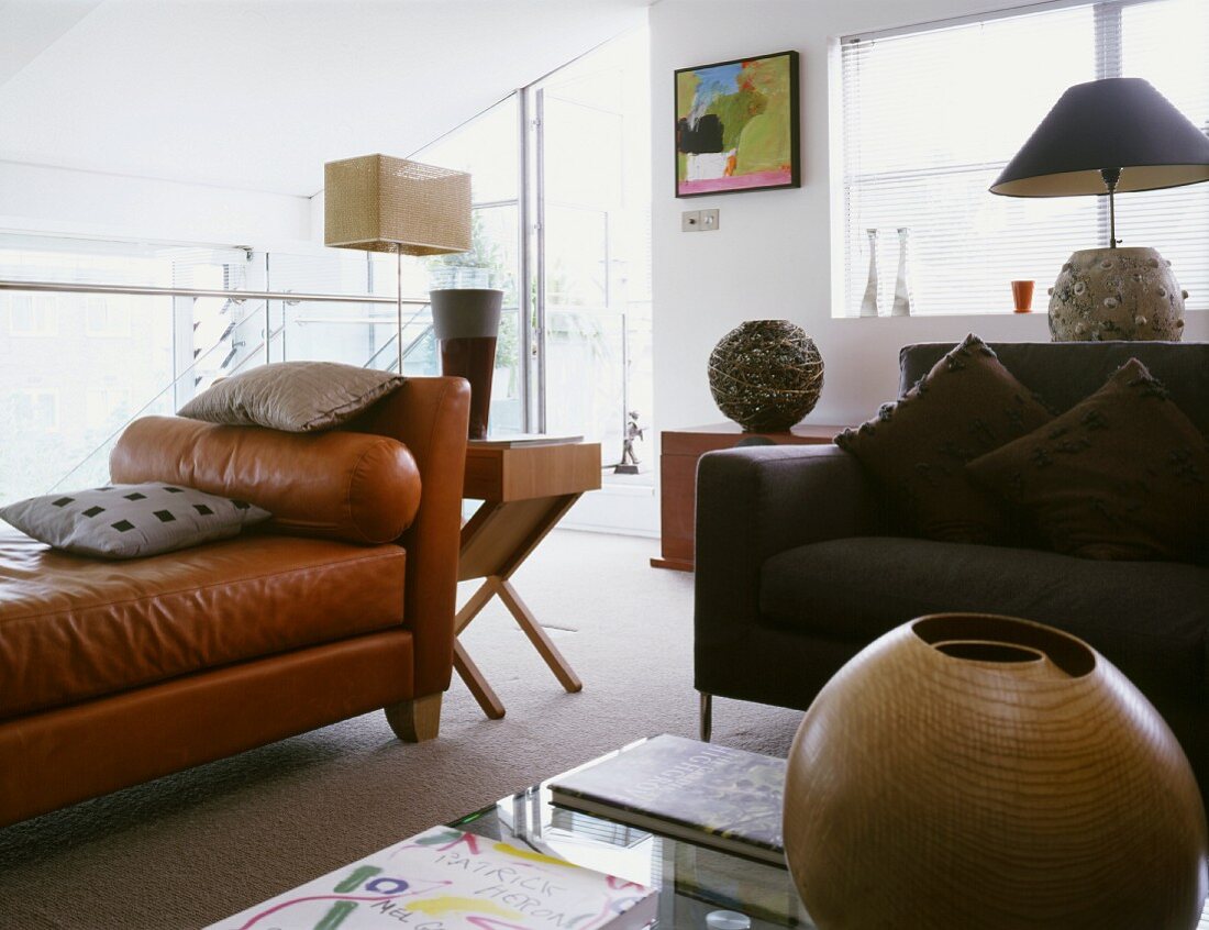 Braune Lederliege und modernes Sofa im offenen Wohnraum