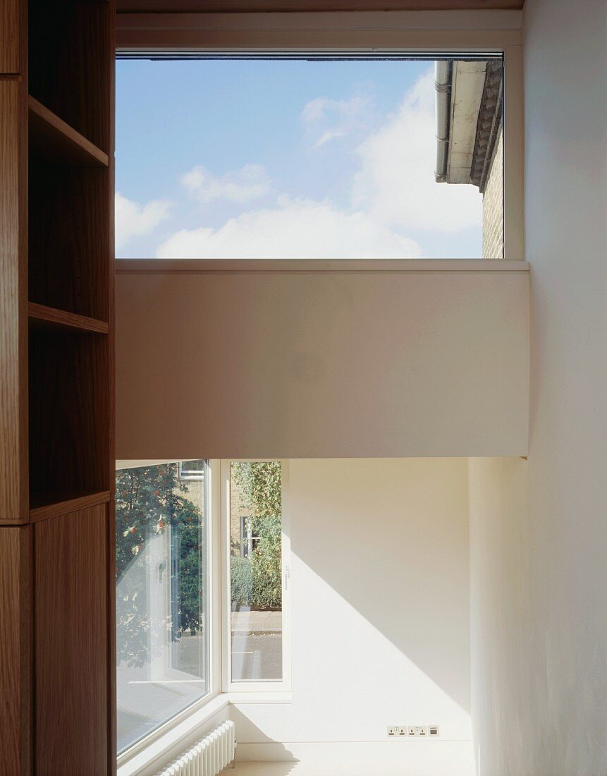 Open room with view of a window on the diagonal and return wall with skylight