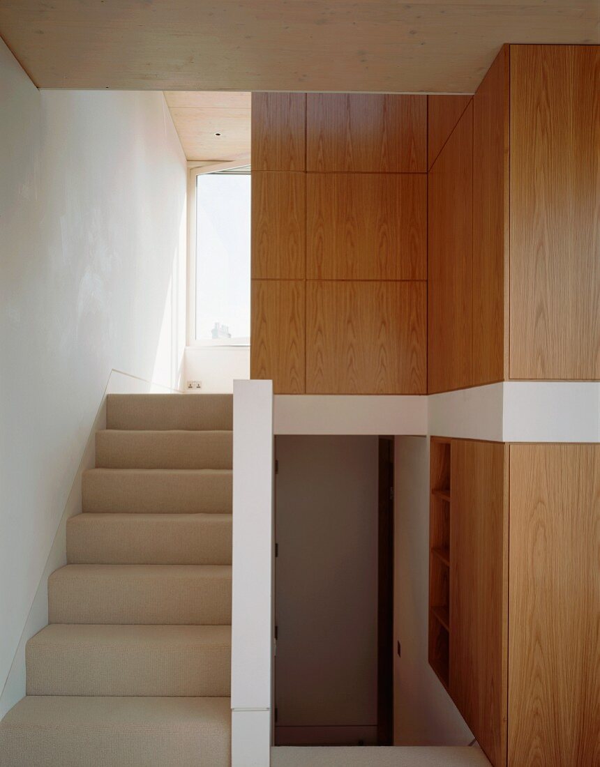 Ascending stairs and wooden built-in cupboards in the stairwell