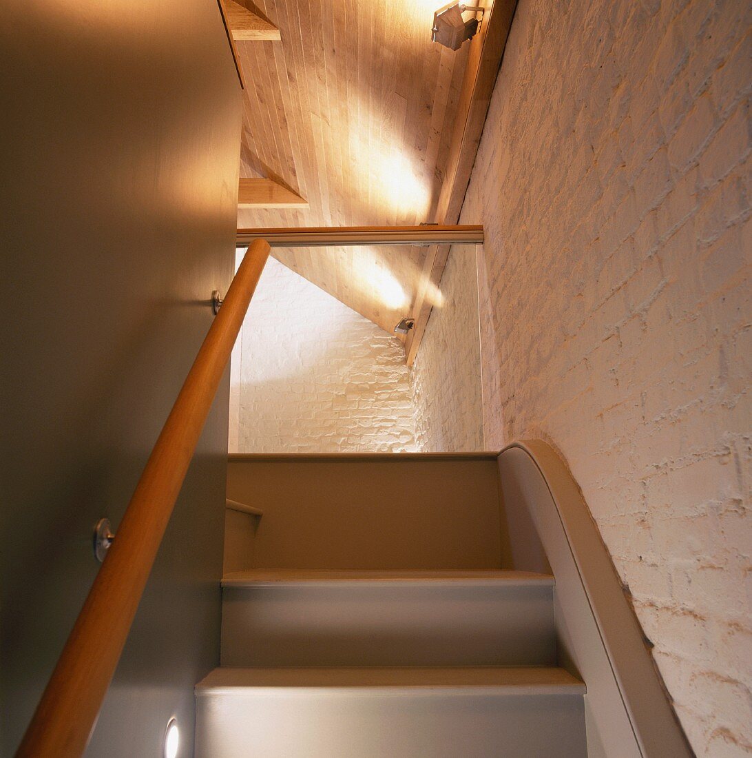 Ausschnitt eines Treppenaufganges ins Dachgeschoss mit geweisselter Ziegelwand