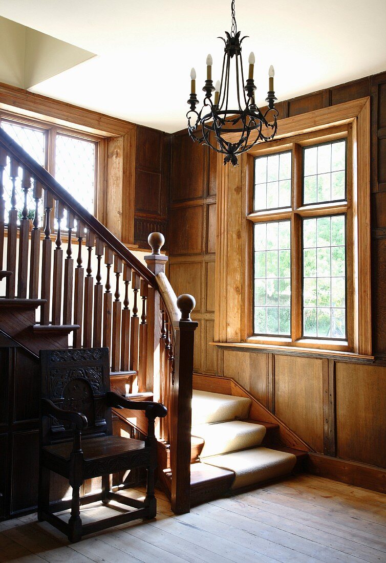 Treppe und Geländer aus Holz in traditionellem Haus mit Holzverkleidung an der Wand