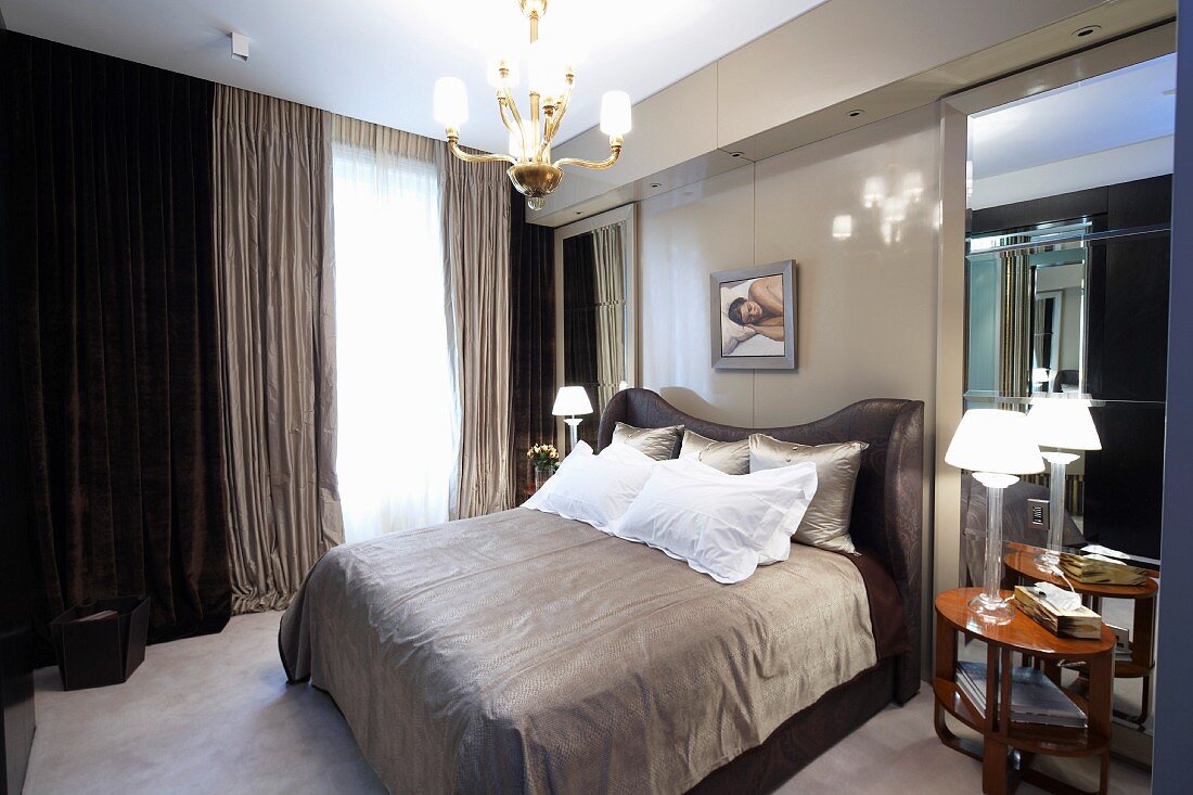 Herrenschlafzimmer in verschiedenen Grautönen mit Doppelbett vor bodenlangen Vorhängen