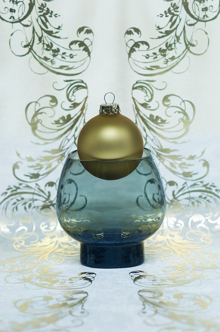 A golden Christmas tree bauble in a vase