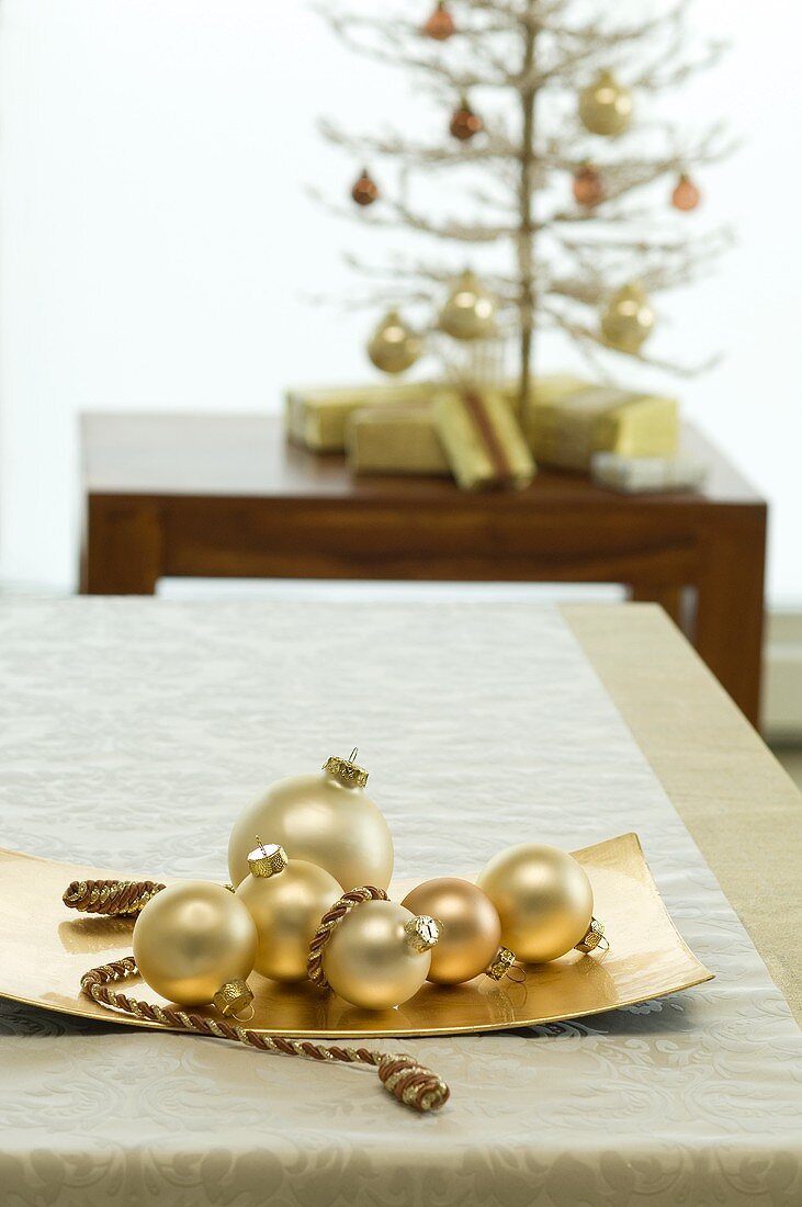 Weihnachtliche Tischdeko mit goldenen Christbaumkugeln