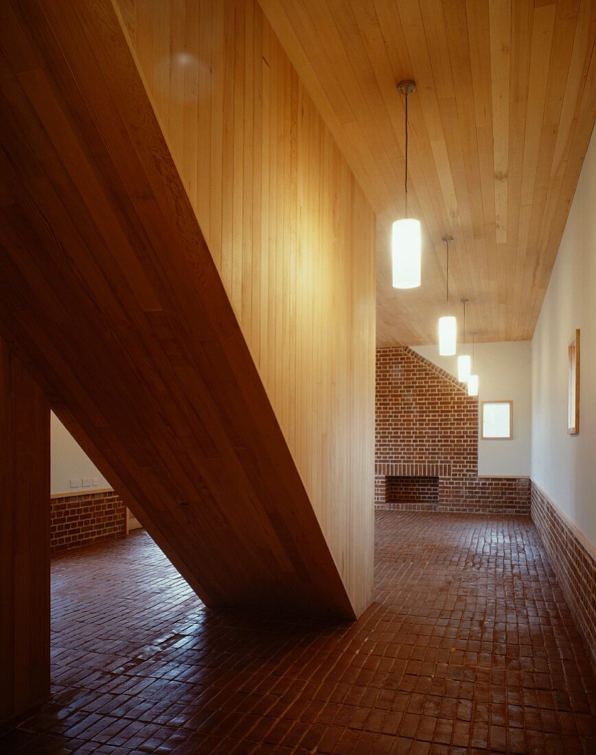 Entry hall with terra-cotta floor and wooden enclosed stairwell
