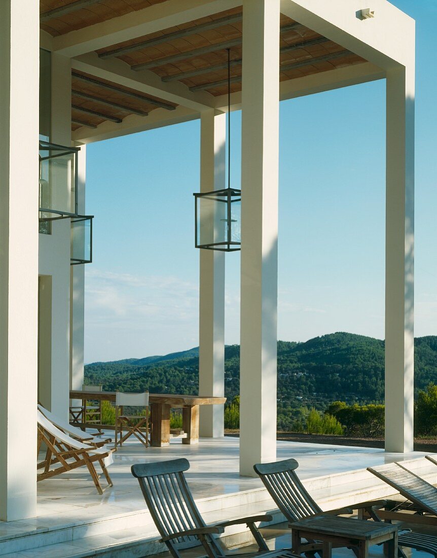 Veranda in zeitgenössischer Villa mit weissen Stützen in Mediterraner Umgebung