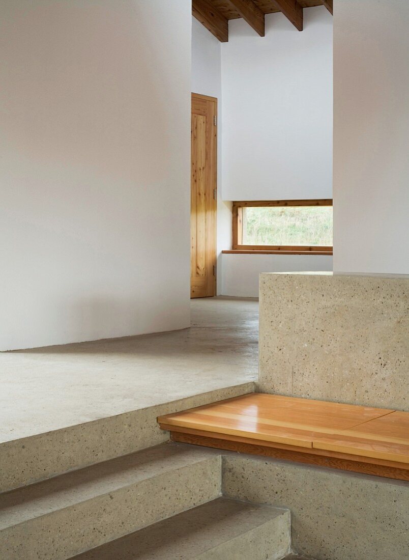 Stairs and bench made of stone with wooden seat in a lobby