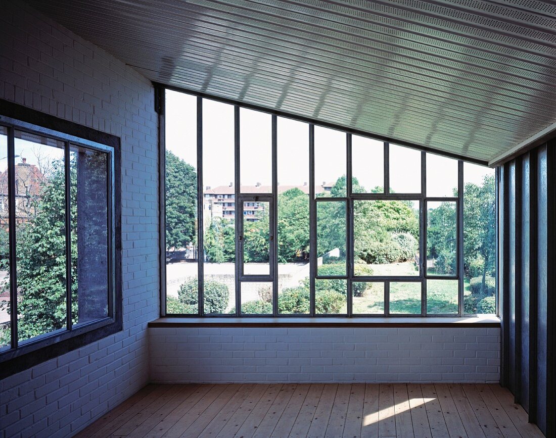 Leerer Raum unter dem Dach mit Fenster und Blick in Garten