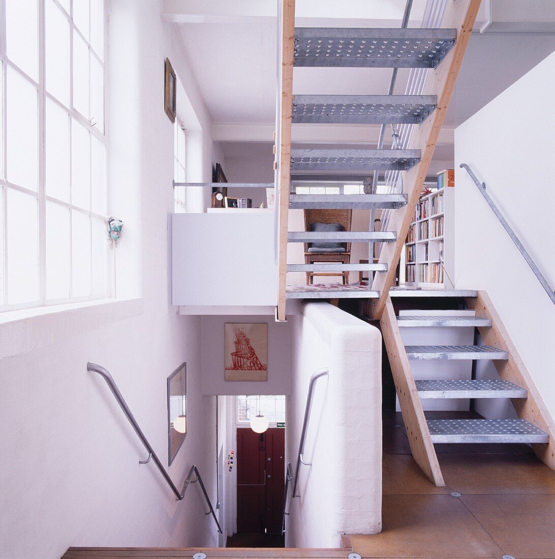 Treppenraum mit weiterführender Treppe und Blick in offenen Wohnraum