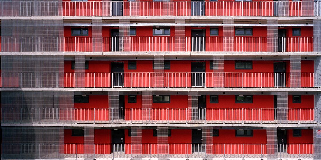 Wohnhaus mit Laubengängen an roter Fassade