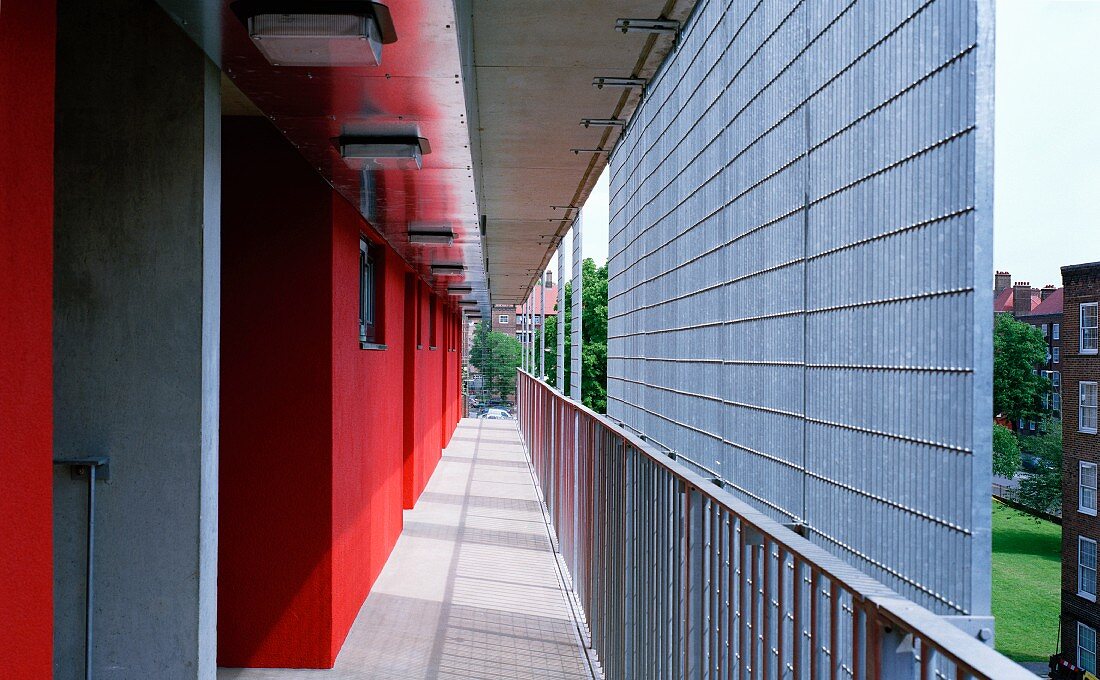 Red house facade with an arcade and a metal grille privacy shield