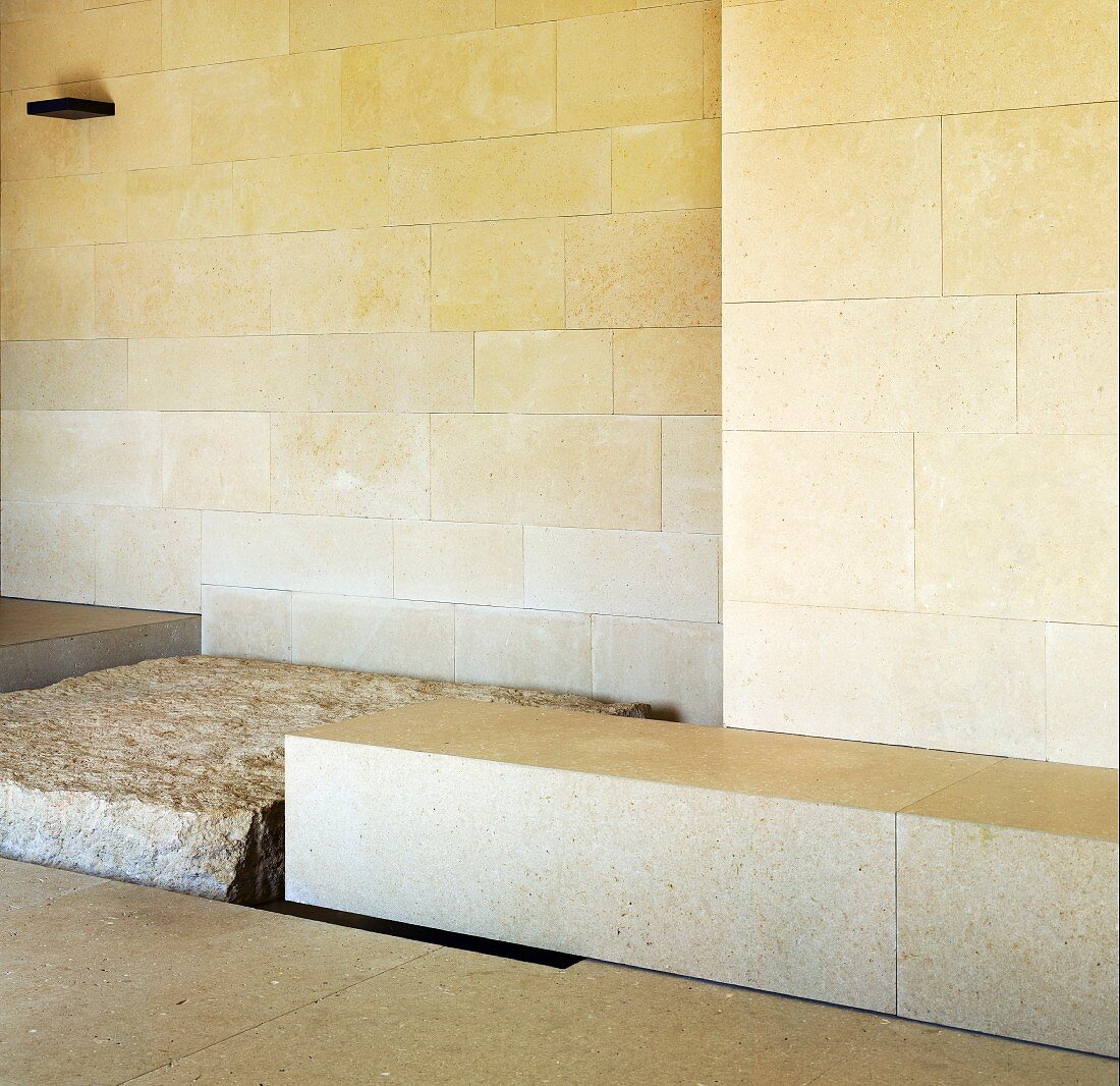 Light colored stone block in front of wall with stone tiles