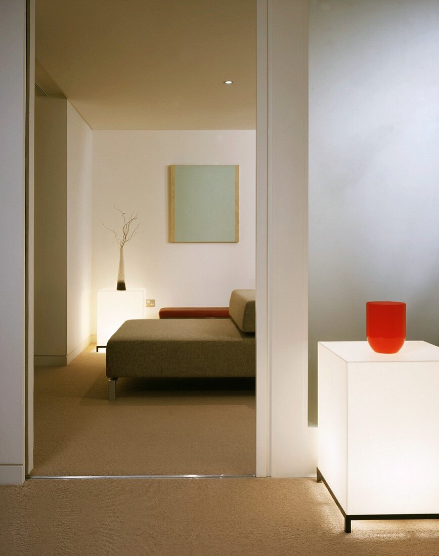 Cube shaped floor lighting next to an open door and view of a modern sofa
