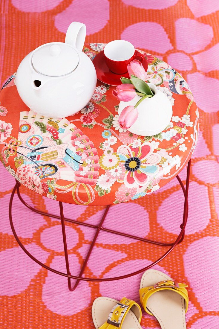A teapot and a teacup on a Moroso table with a floral pattern
